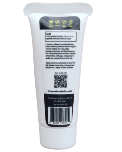 A tube of Manuka Butter, an all-natural topical solution for skin ailments. The white squeeze tube and label with an orange leaf illustration, containing whipped cream-colored butter